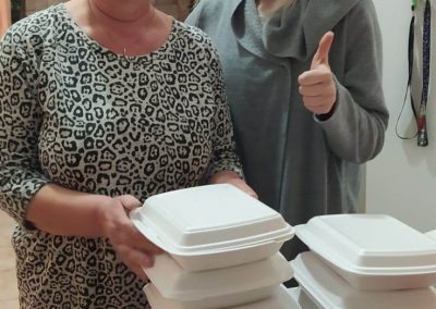 Dvě zástupkyně azylového domu s boxy s jídlem.