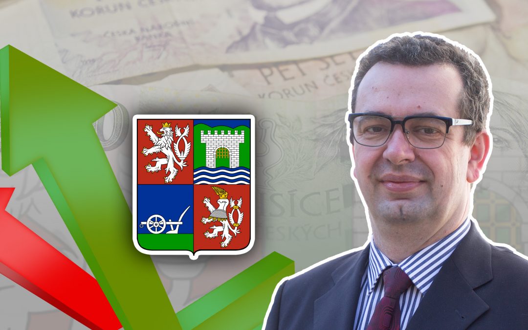 Vladimír Vlach stojí před pozadím s ilustračním obrázkem k rozpočtu. jedná se o změť českých bankovek a šipka.